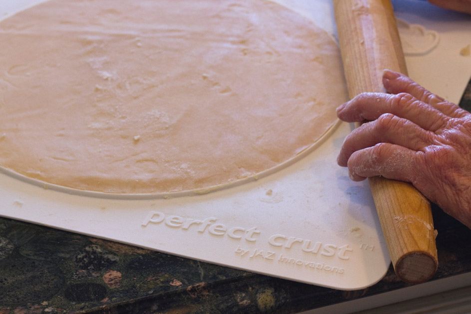 Pastry mat with pie dough laid out and rolling pin used to make pie dough