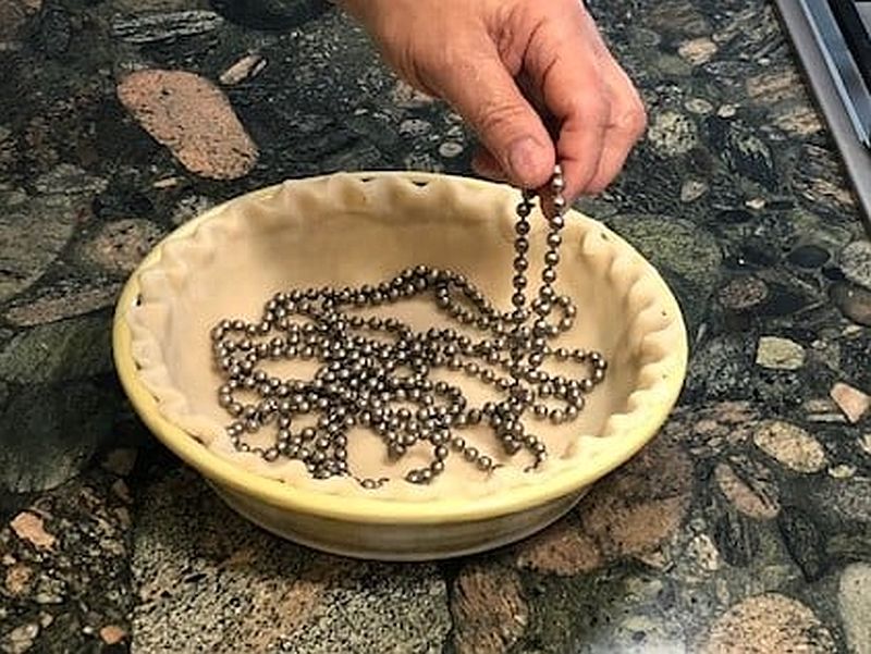 Taking a pie weight chain out of a cooked pie crust