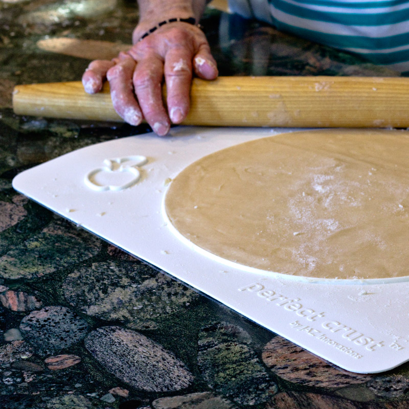 Rolling pin rolling out pie dough using the Perfect Crust™ Pie Mat