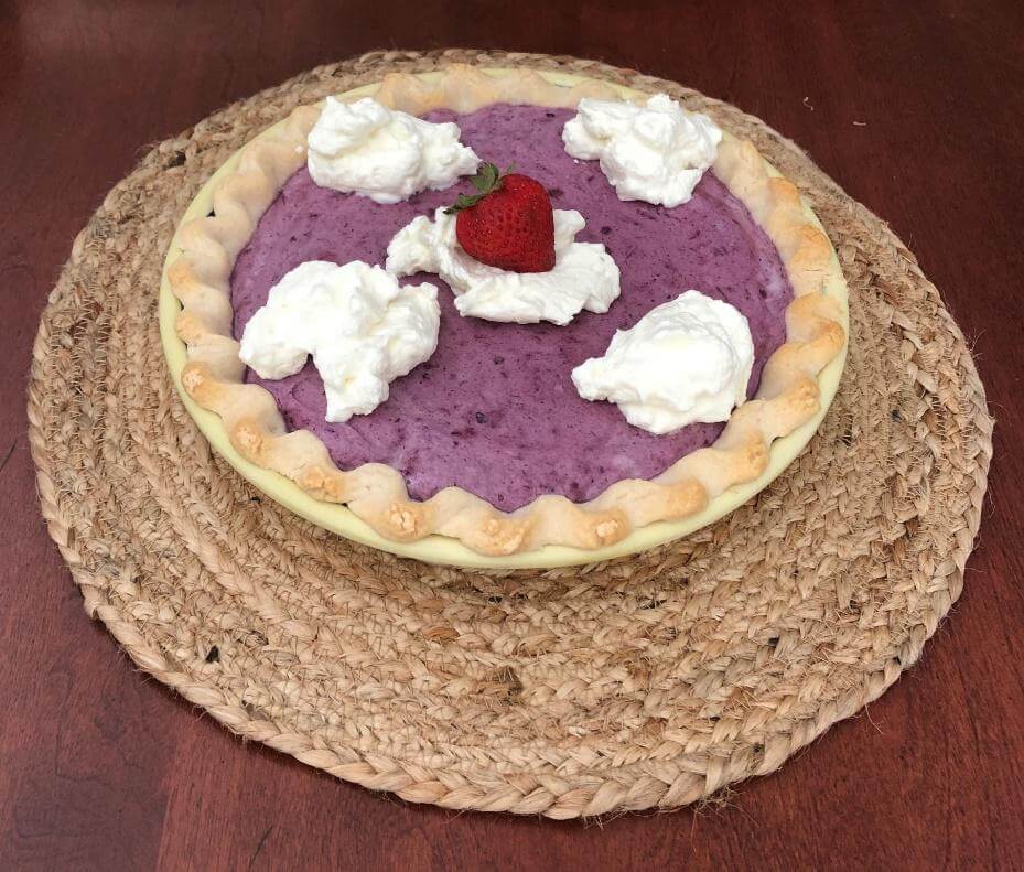 Blueberry Chiffon Pie with whipped cream and strawberries